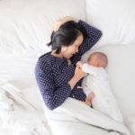 mother breastfeeding baby in bed